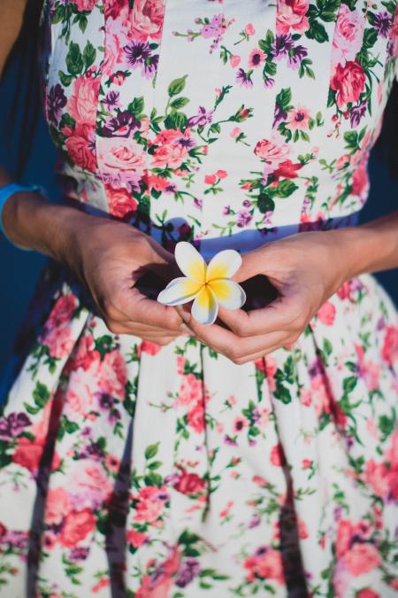 Woman in White and Green Floral Dress Holding Flower