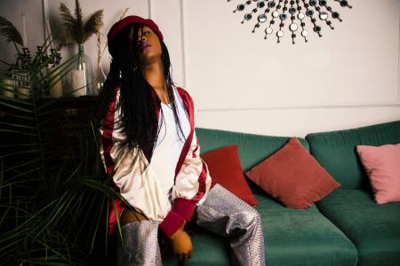 Woman in White and Red Jacket Sitting on Green Couch