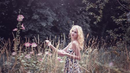 Woman in White Black and Green Floral Tube Dress Standing on Green Grass Field during Daytime