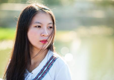 Woman in White, Blue, and Maroon Top Facing Right