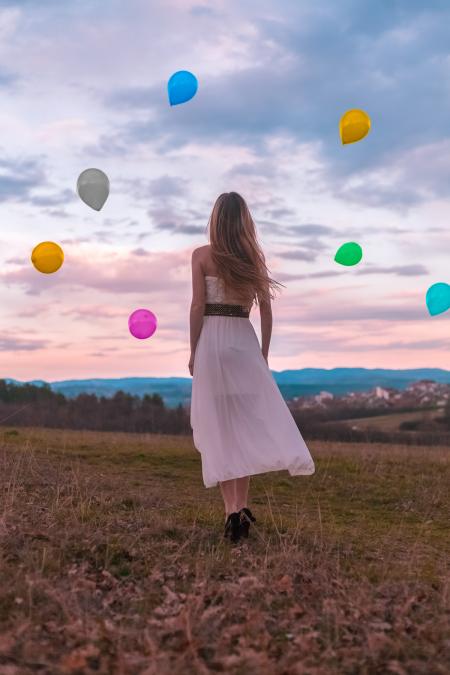 Woman in White Dress Looking at the Balloons