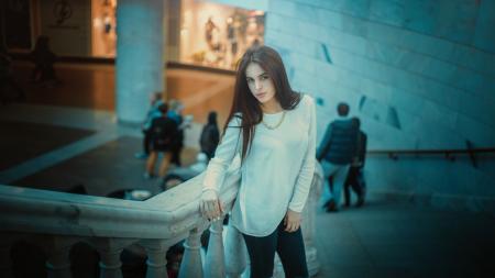 Woman in White Long Sleeve Shirt Posing Beside Gray Concrete Staircase