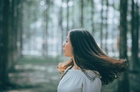 Woman in White Off-shoulder Dress Near Trees