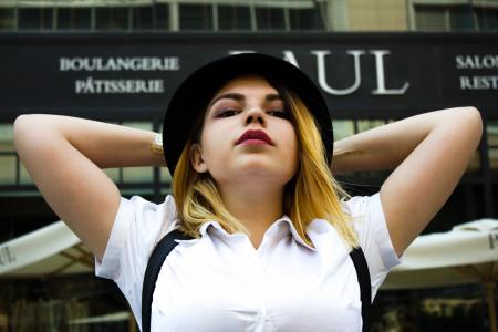 Woman in White Polo Shirt Wearing Black Fedora Hat