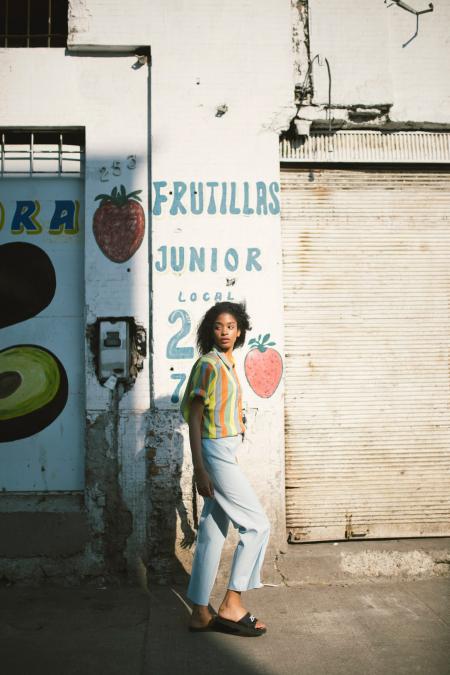 Woman in Yellow Mid-sleeved Shirt Standing Beside White Wall