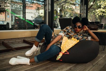 Woman Lying on Black Bean Bag Chair Near Cafe