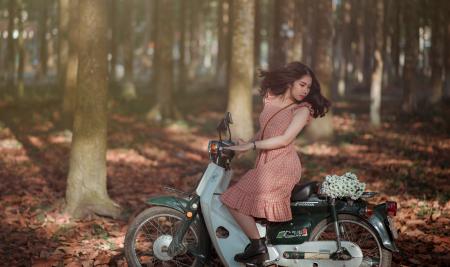 Woman Riding Black and White Motor Scooter in Jungle