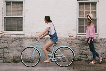 Woman Riding on Teal Cruiser Bike Near Woman Wearing Pink Long-sleeved Shirt