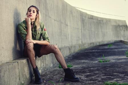 Woman Sits Besides Gray Concrete Wall