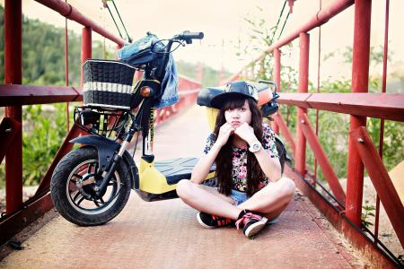 Woman Sitting on Bridge With Motor Scooter