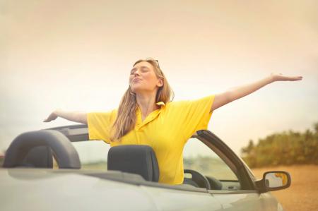 Woman Sitting on Car Under Gray Sky