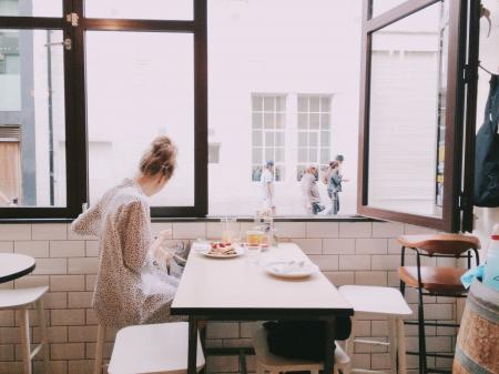 Woman Sitting on Chair and Wearing Black and Gray Blouse