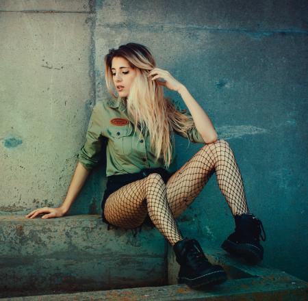 Woman Sitting on Concrete Seat While Wearing Green Button-up Long-sleeved Shirt and Mesh Stockings