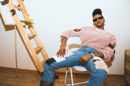 Woman Sitting on Folding Chair Near Wall