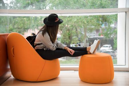 Woman Sitting on Orange Chair