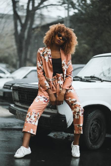 Woman Sitting on White Car Hood