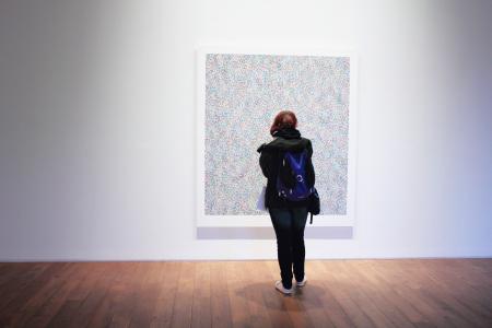 Woman Standing Infront of a Wall Mount Painting