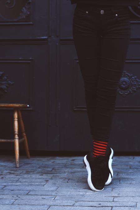 Woman Standing Leaning on Brown Surface