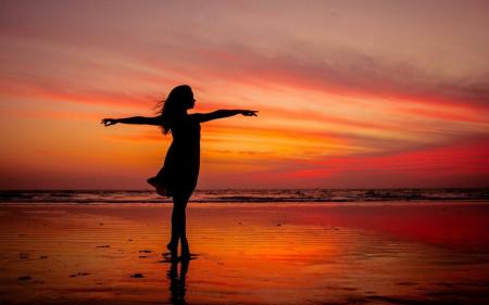 Woman Standing on Beach during Sunset