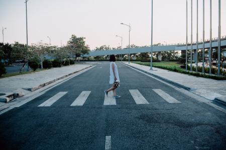 Woman Standing on Gray and White Road Crosswalk