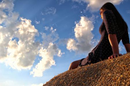 Woman Standing on Mountain Against Cloudy Sky