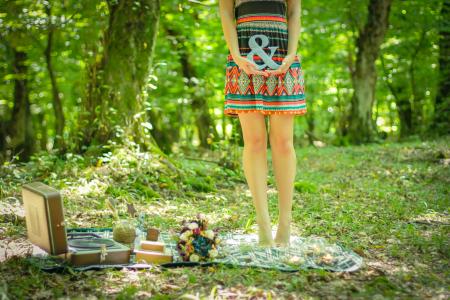 Woman Standing on Picnic Mat Holding Ampersand Lettering