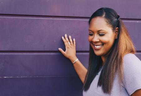 Woman Standing Touching Gray Wall Wearing Gray Shirt