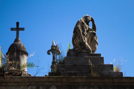 Woman Statue Near Cross during Daytime