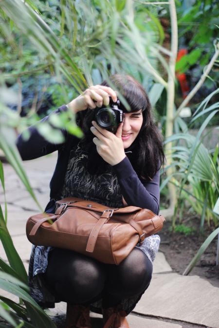 Woman Taking Picture While Holding Brown Leather Bag