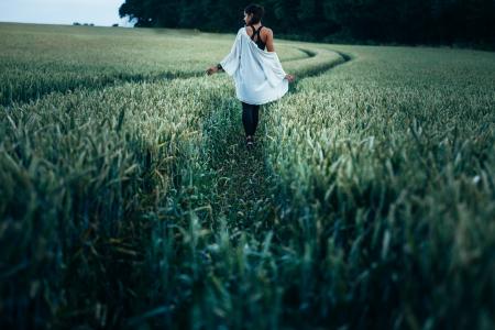 Woman Walking in the Rice Plant Field during Daytime