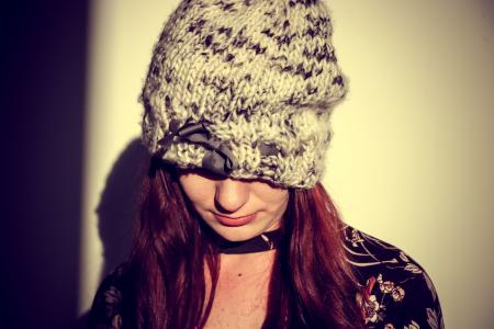 Woman Wearing Black and Gray Knit Cap in the White Wall Paint Room