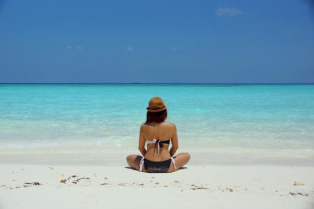 Woman Wearing Black and White Brassiere Sitting on White Sand