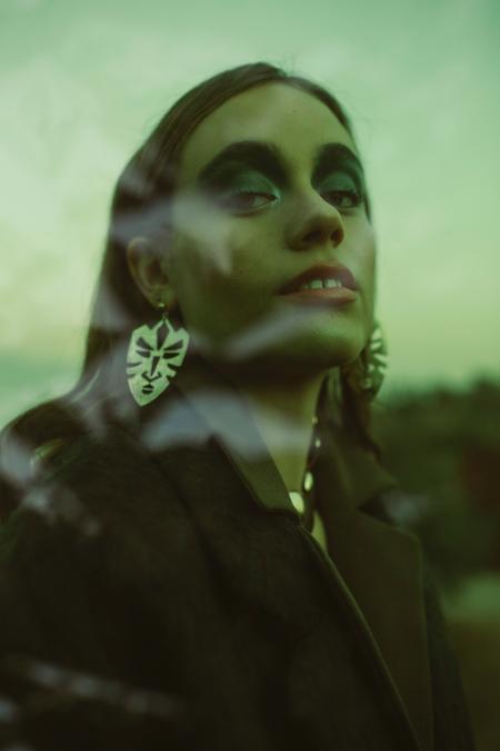 Woman Wearing Black Coat and Silver Earrings