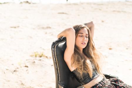 Woman Wearing Black Crop Top With Black Floral Bottoms Sitting on Chair