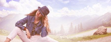 Woman Wearing Black Fedora Hat, Blue Denim Blazer and White Skinny Jeans While Sitting on Ground