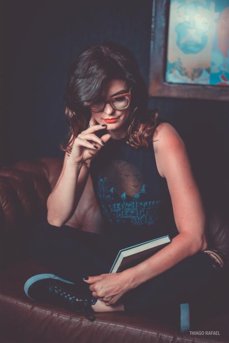 Woman Wearing Black Graphic Printed Tank Top and Pants Sitting on Brown Leather Sofa