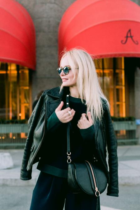 Woman Wearing Black Leather Jacket Near Brown and Red Building