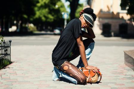 Woman Wearing Black T-shirt Kneeling on Ground