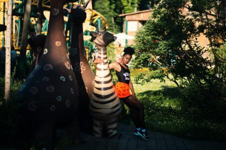 Woman Wearing Black Tank Top Near Zebra Statue