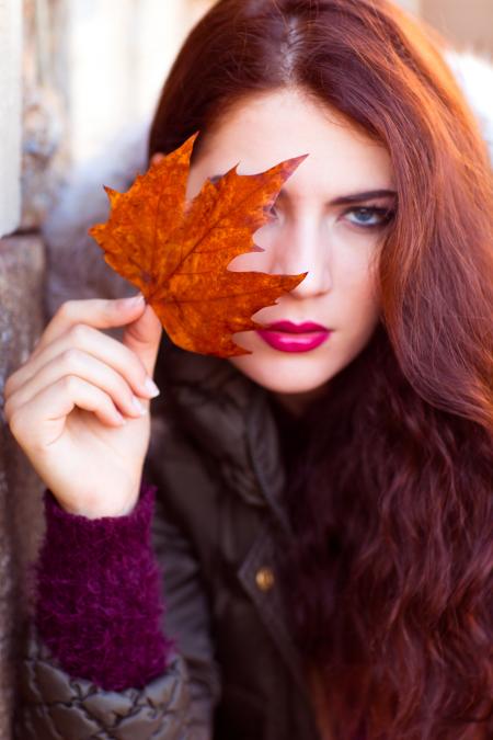 Woman Wearing Black Zip-up Jacket Holding Brown Maple Leaf