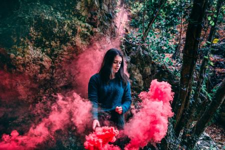 Woman Wearing Blue Long Sleeved Shirt Standing On Pink Smoke