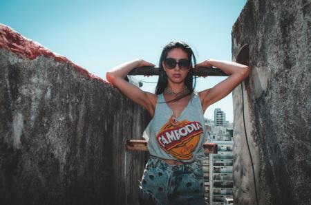 Woman Wearing Blue Tank Top Beside Concrete Walls