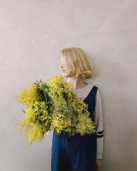 Woman Wearing Blue V-neck Sleeveless Top While Holding Yellow Petaled Flower