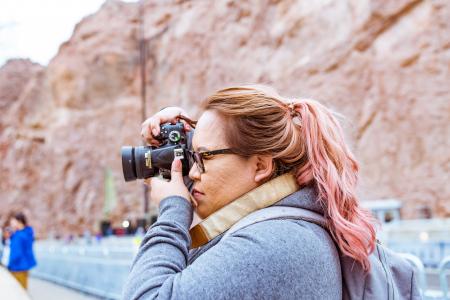 Woman Wearing Gray Jacket Using Black Dslr Camera