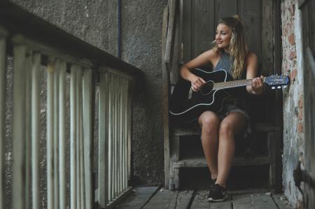 Woman Wearing Gray Tank Top Playing Black Cutaway Acoustic Guitar