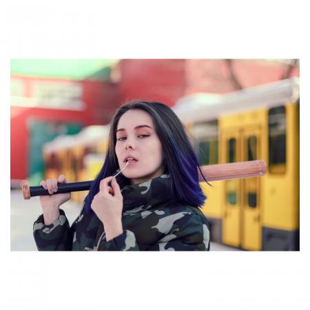 Woman Wearing Green and Beige Camouflage Jacket While Holding Black and Brown Baseball Bat