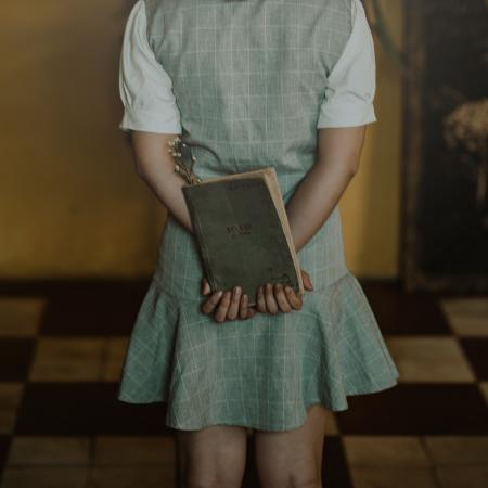 Woman Wearing Grey Dress Holding Book