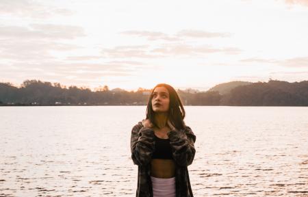 Woman Wearing Jacket Standing Near The Ocean