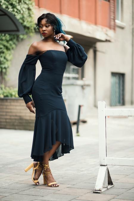 Woman Wearing Off-shoulder Standing Next to White Road Blockage