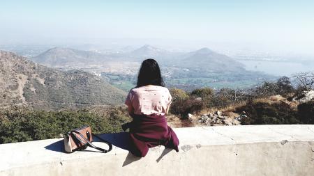 Woman Wearing Pink Shirt Sitting on Gray Concrete Rail